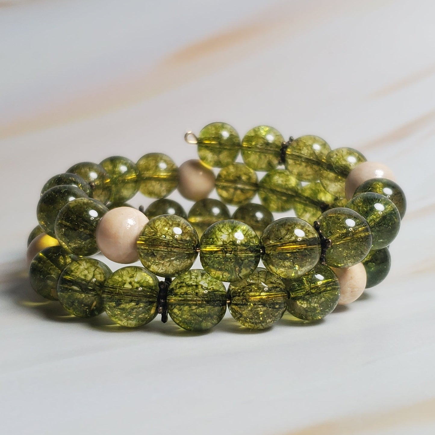Green beaded bracelet on a marble surface