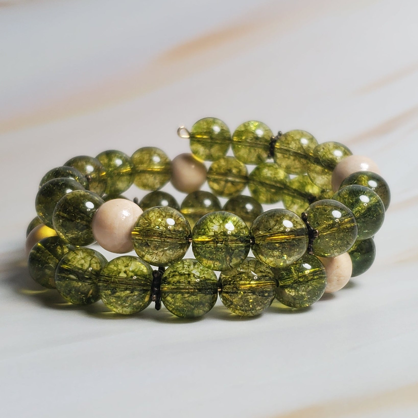 Green beaded bracelet on a marble surface
