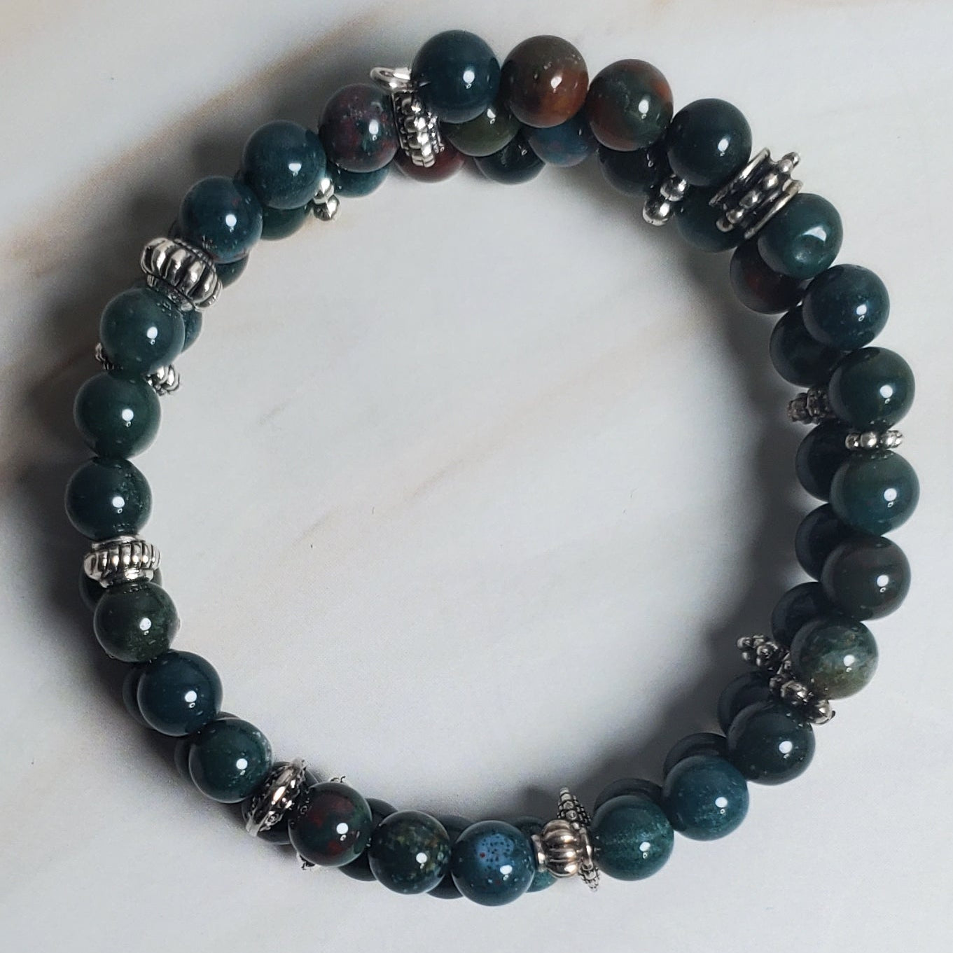 Green beaded bracelet on a light wood surface