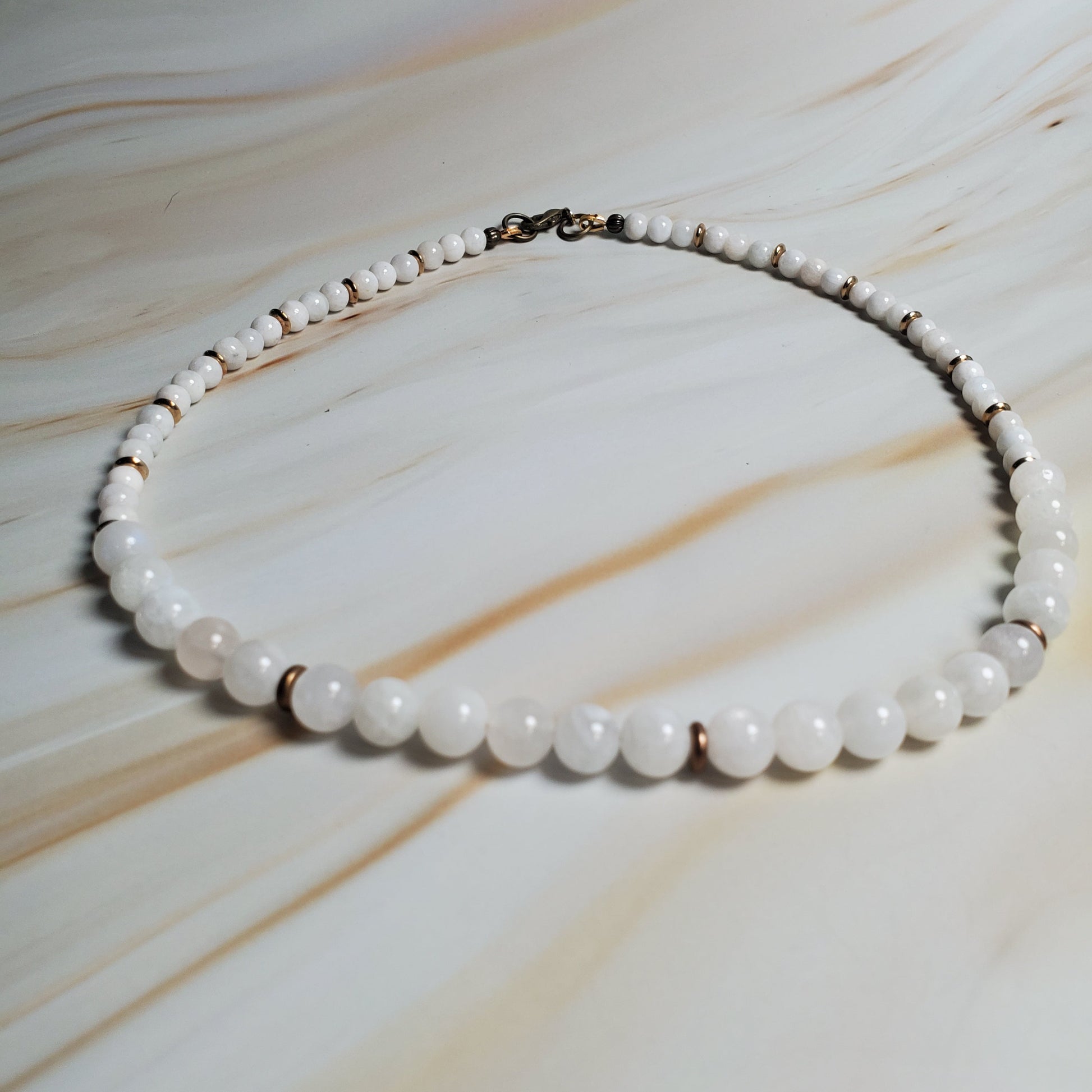 White beaded necklace on a marble surface