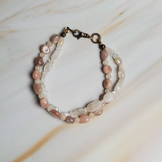 Bracelet with pink and white beads on a marble surface
