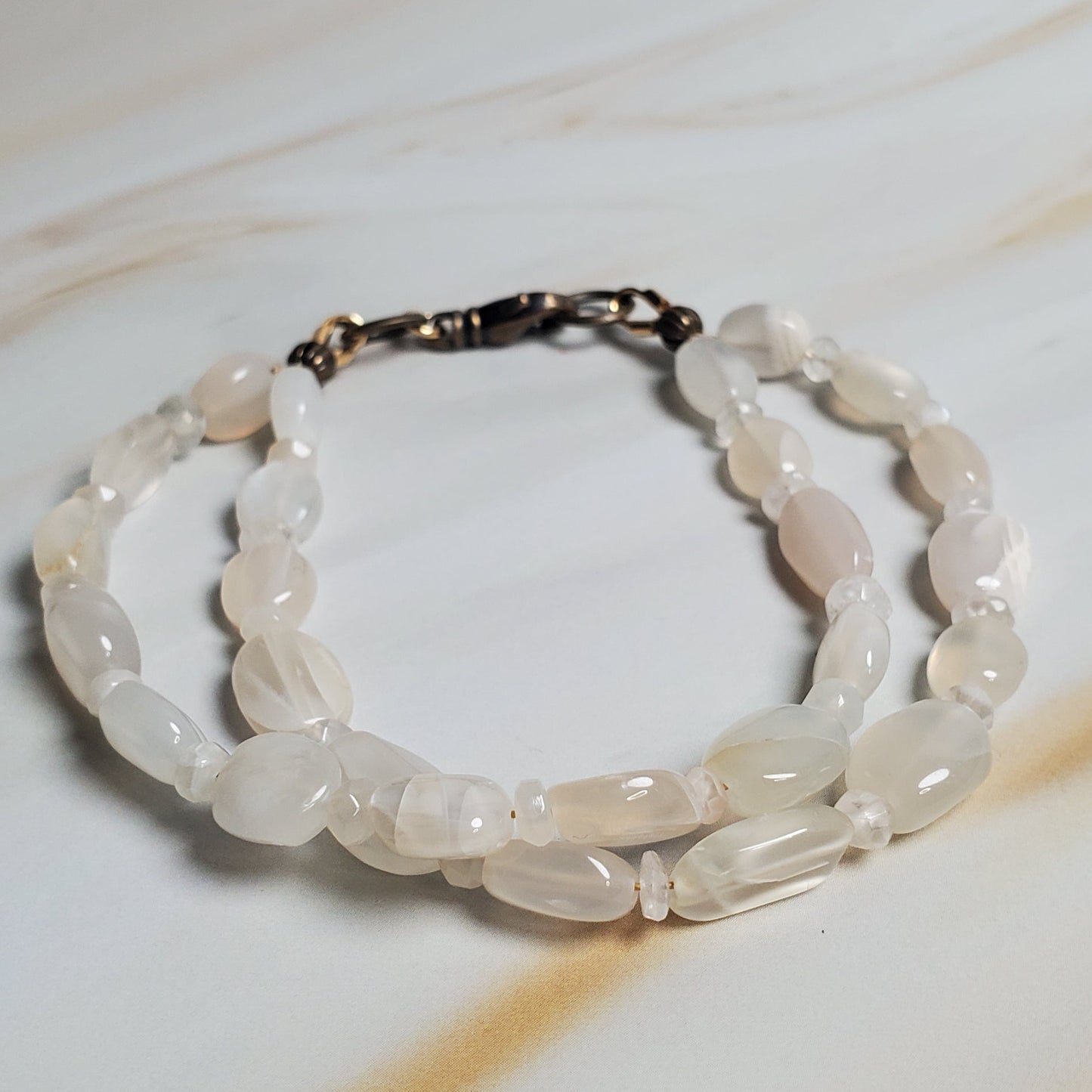 Bracelet with white beads on a textured beige background