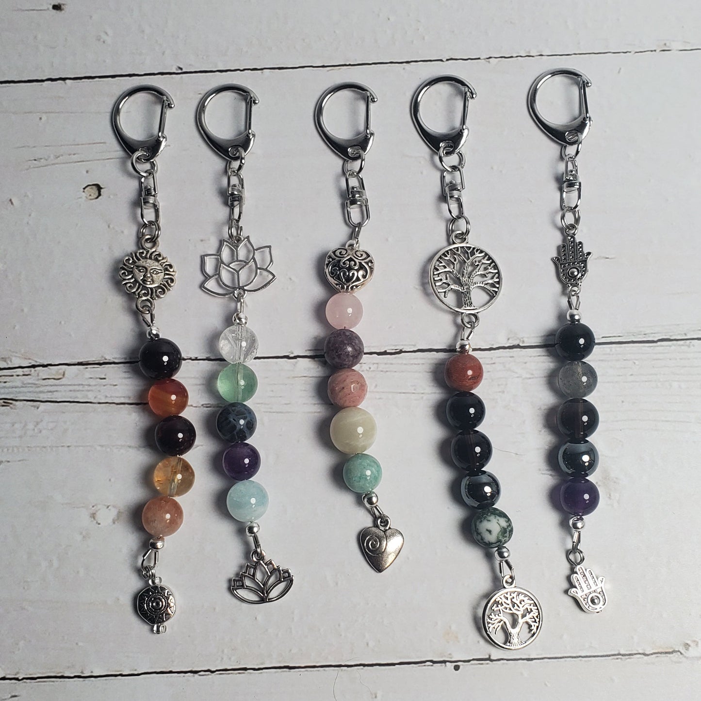 Set of beaded Intention clips on a white wooden surface