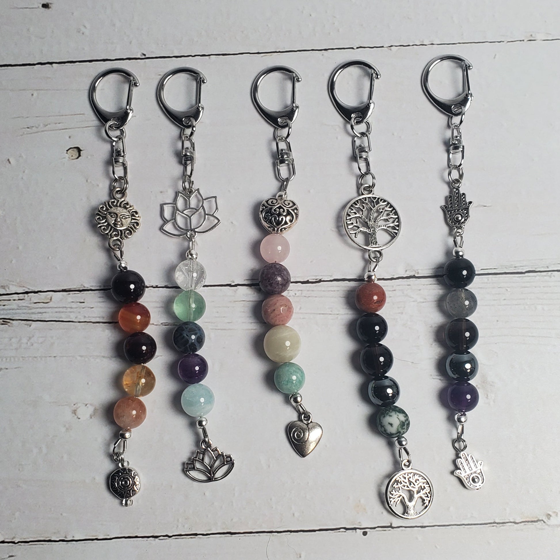 Set of beaded Intention clips on a white wooden surface