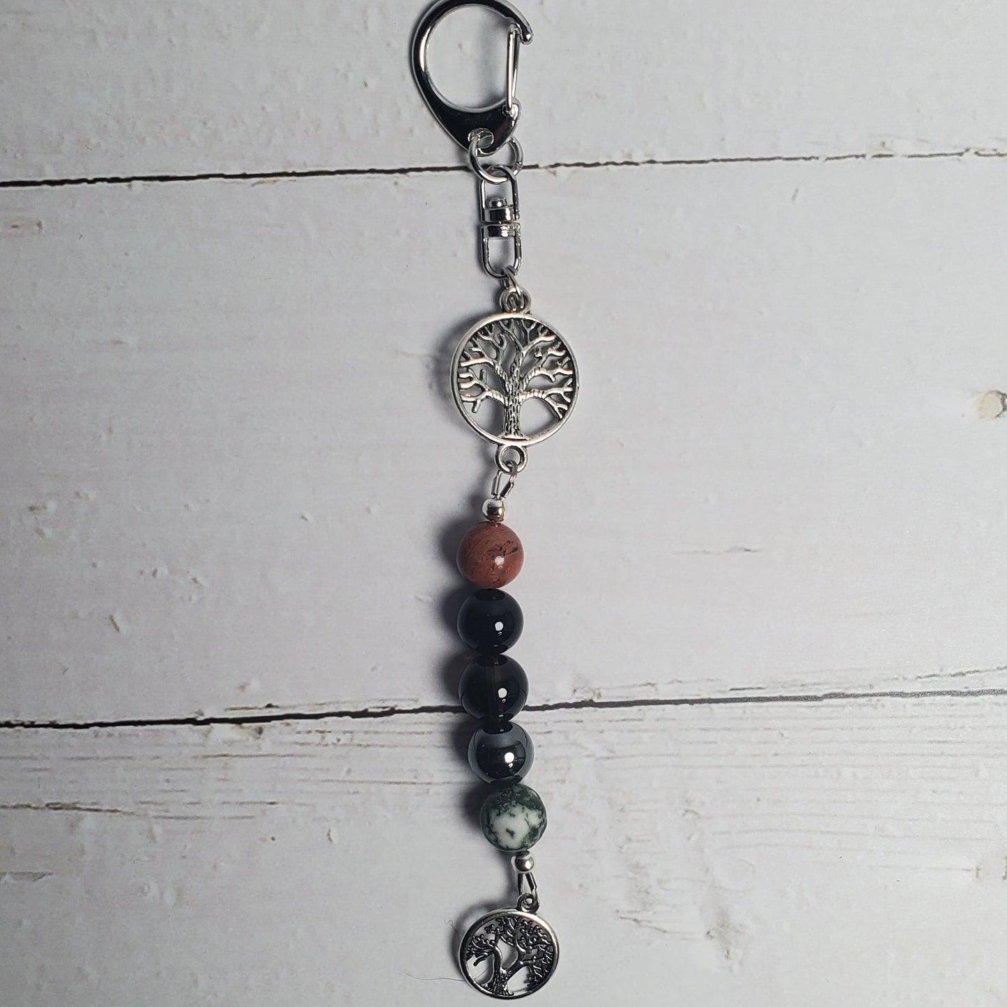Intention Clip with beads and charms on a white wooden surface
