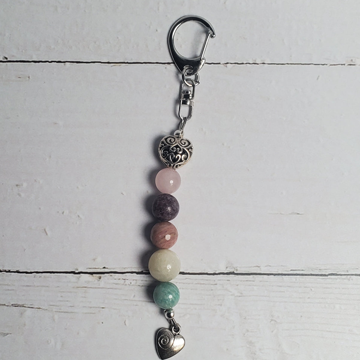 Beaded keychain with metal clasp on a light wooden surface