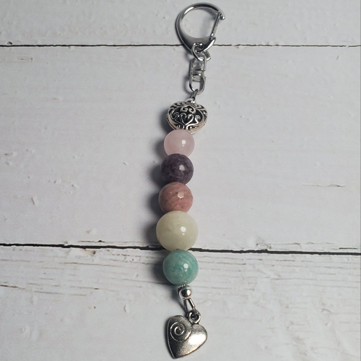 Beaded keychain with heart charm on a light wooden surface