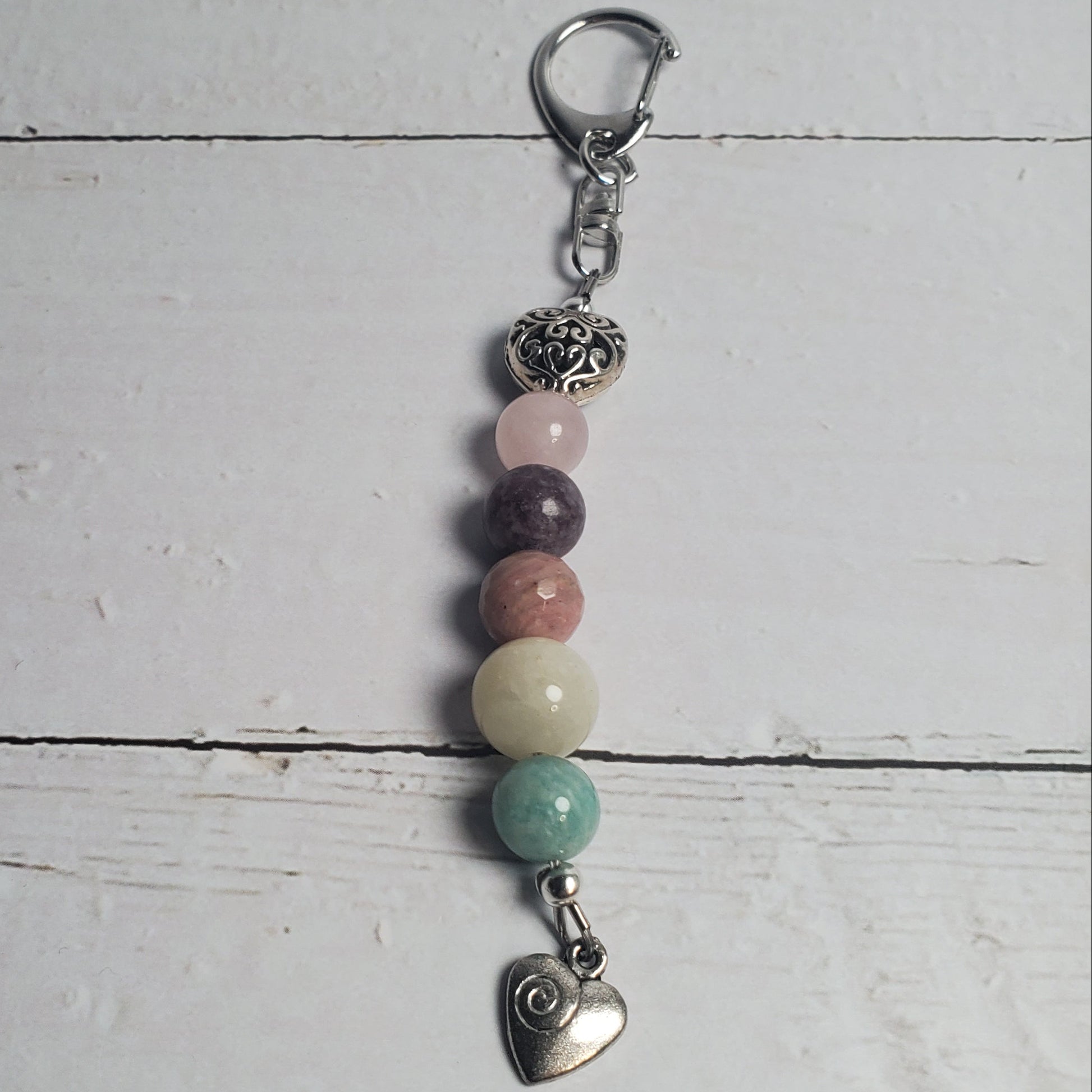 Beaded keychain with heart charm on a light wooden surface