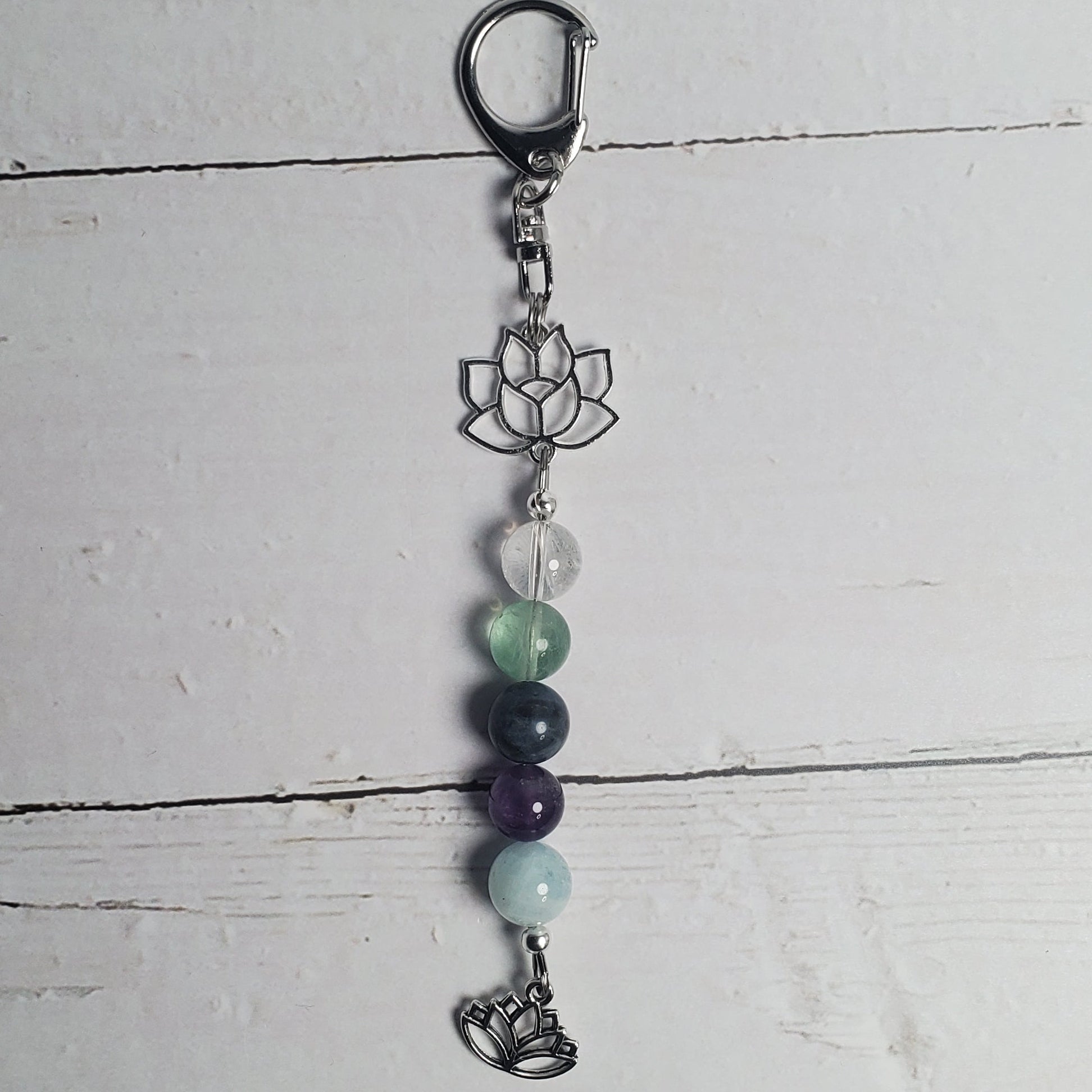 Keychain with beads and a metal clasp on a white wooden surface
