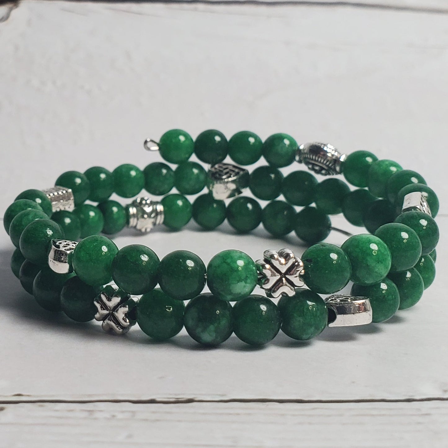 Green beaded bracelet on a white wooden surface