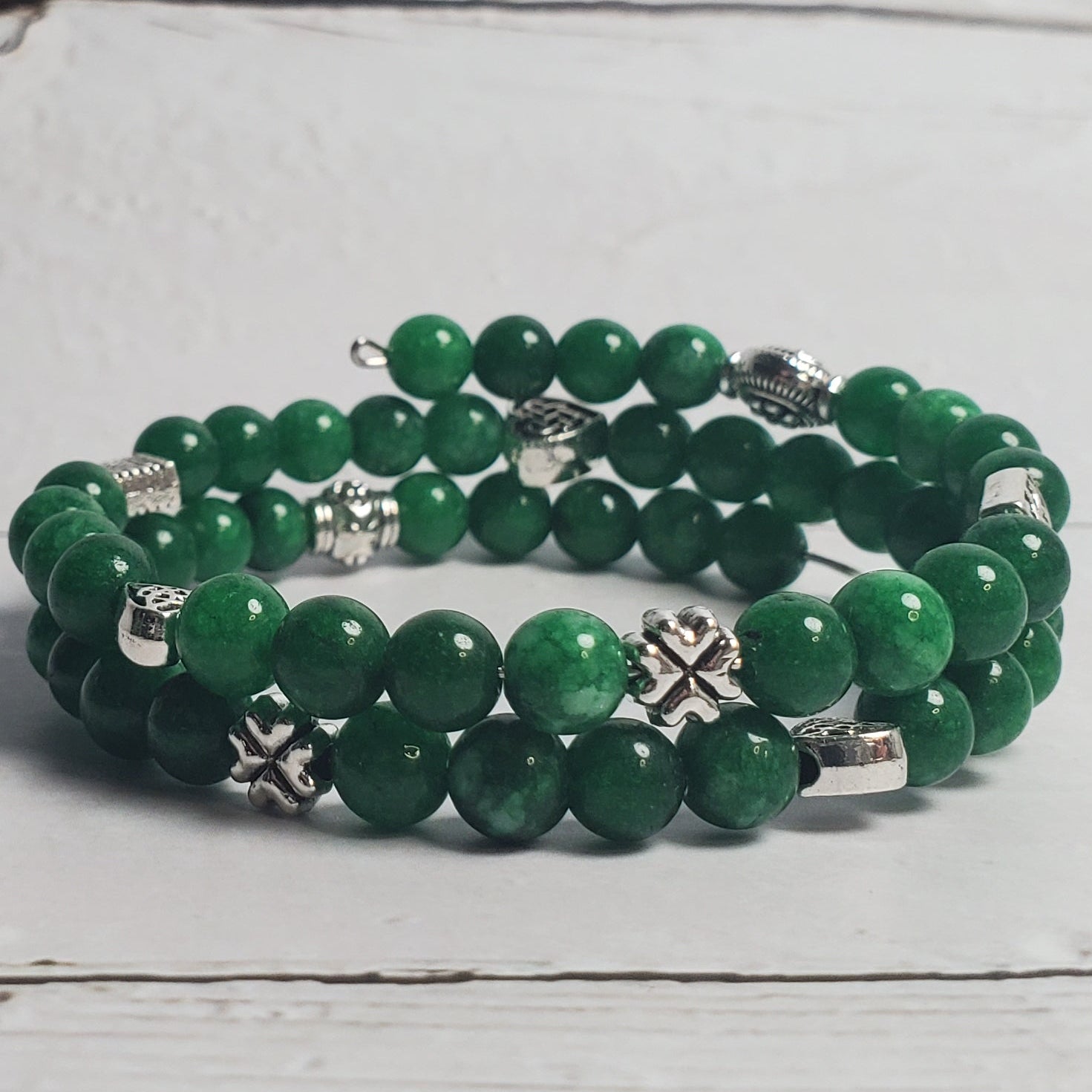 Green beaded bracelet on a white wooden surface