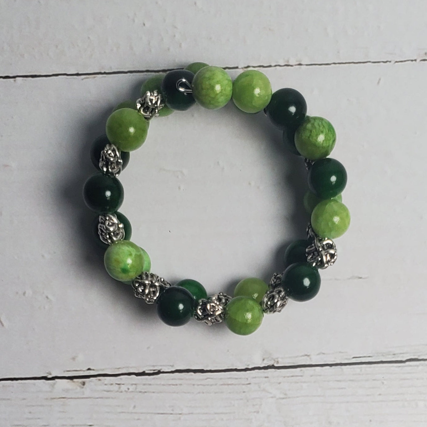 Green beaded bracelet on a white wooden surface