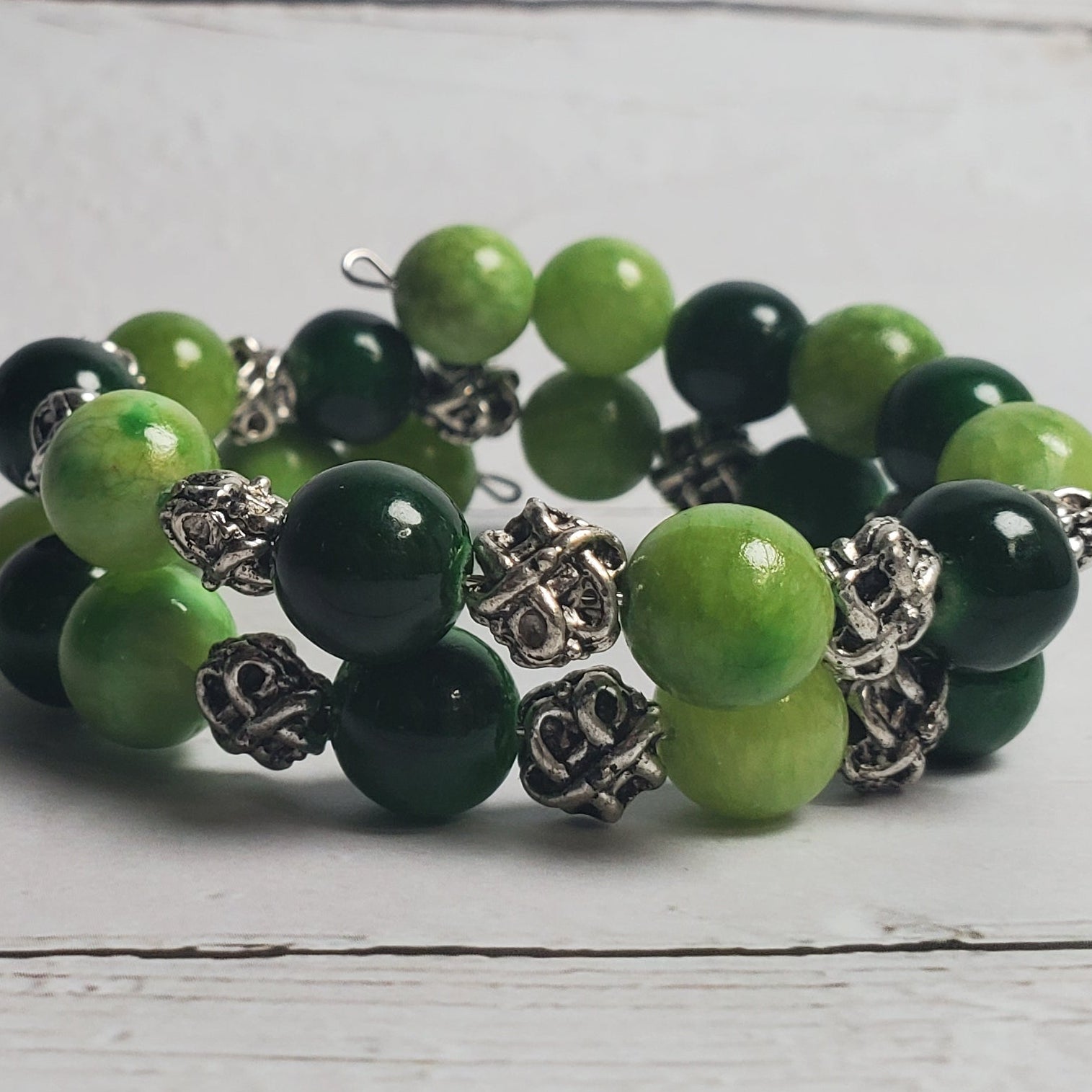 Green beaded bracelet on a light wooden surface