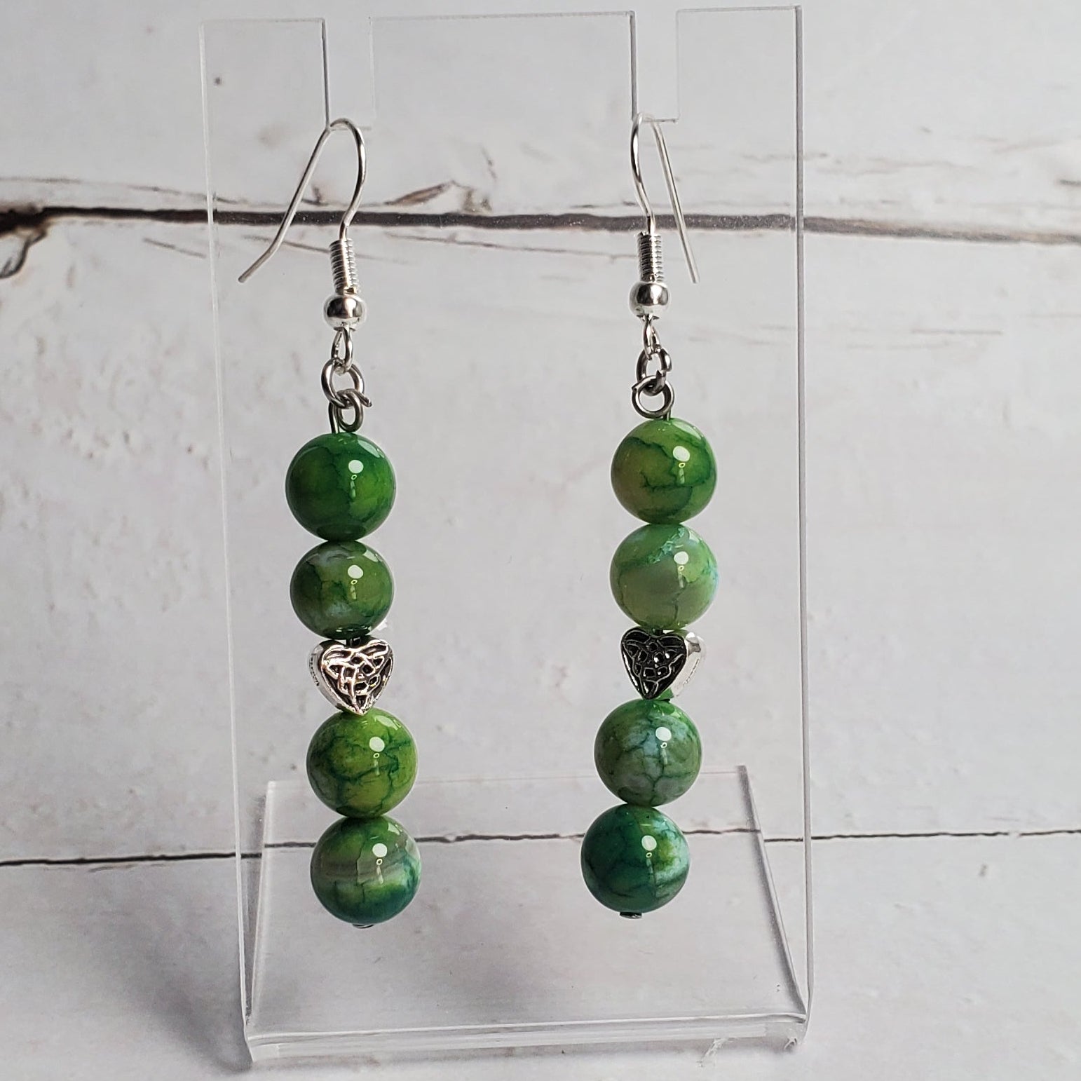 Green beaded bracelet on a white wooden surface