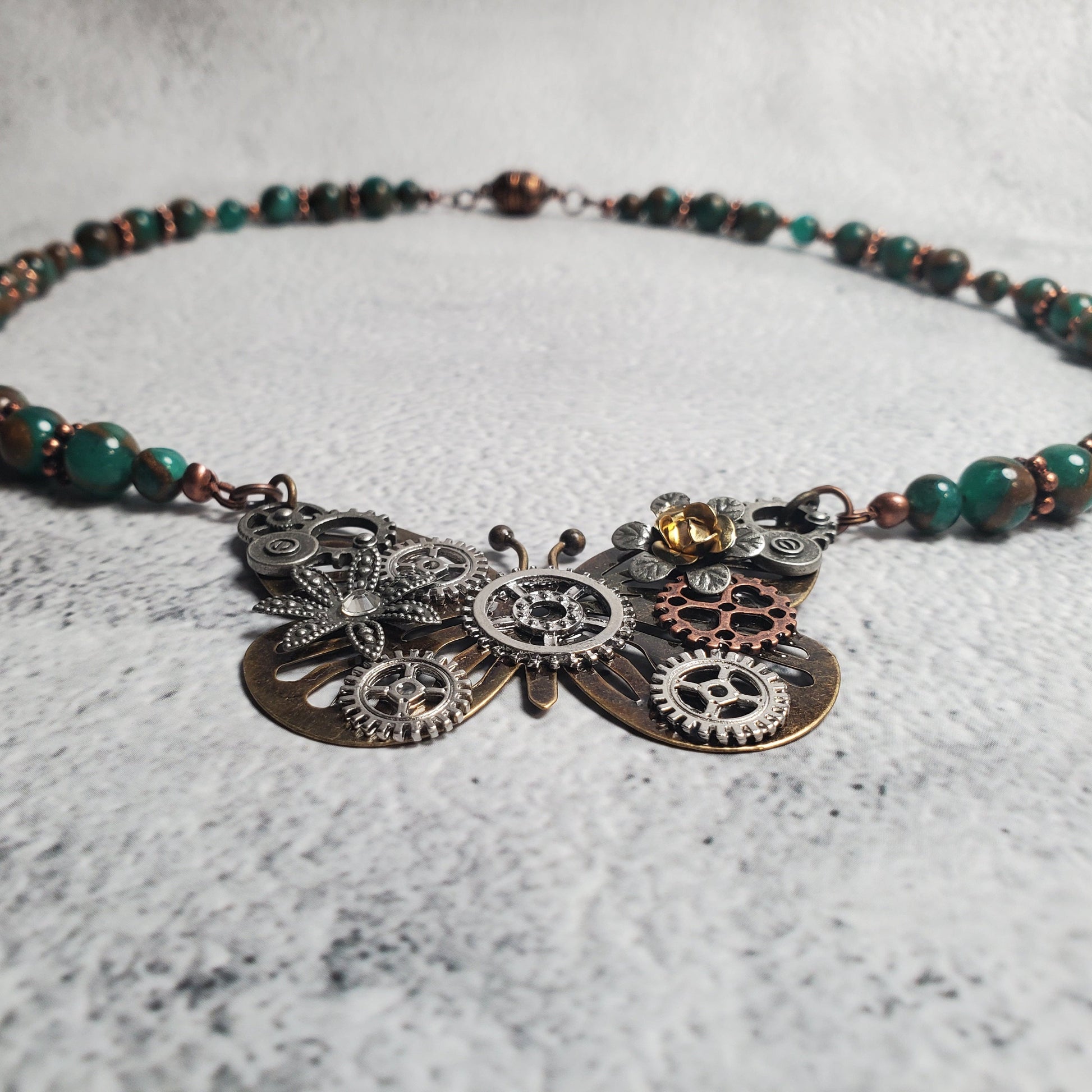 Handcrafted industrial style necklace with mechanical butterfly pendant, green resin beads, and copper accents