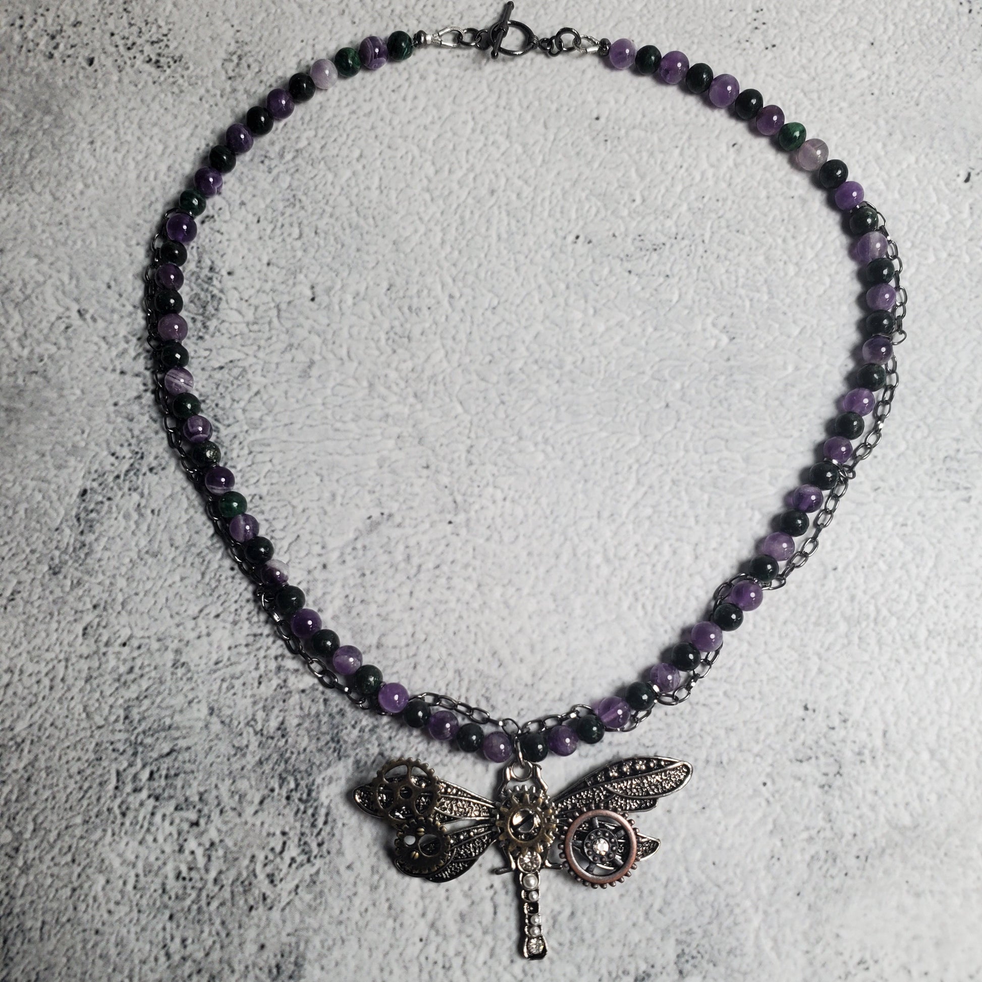 Industrial style necklace with mechanical dragonfly pendant and amethyst gemstones on gunmetal chain