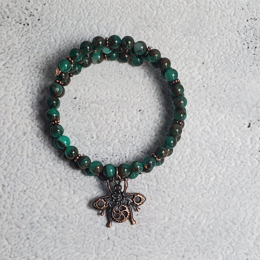 Handcrafted steampunk industrial bracelet with copper beetle charm and green resin sponge quartz on memory wire cuff
