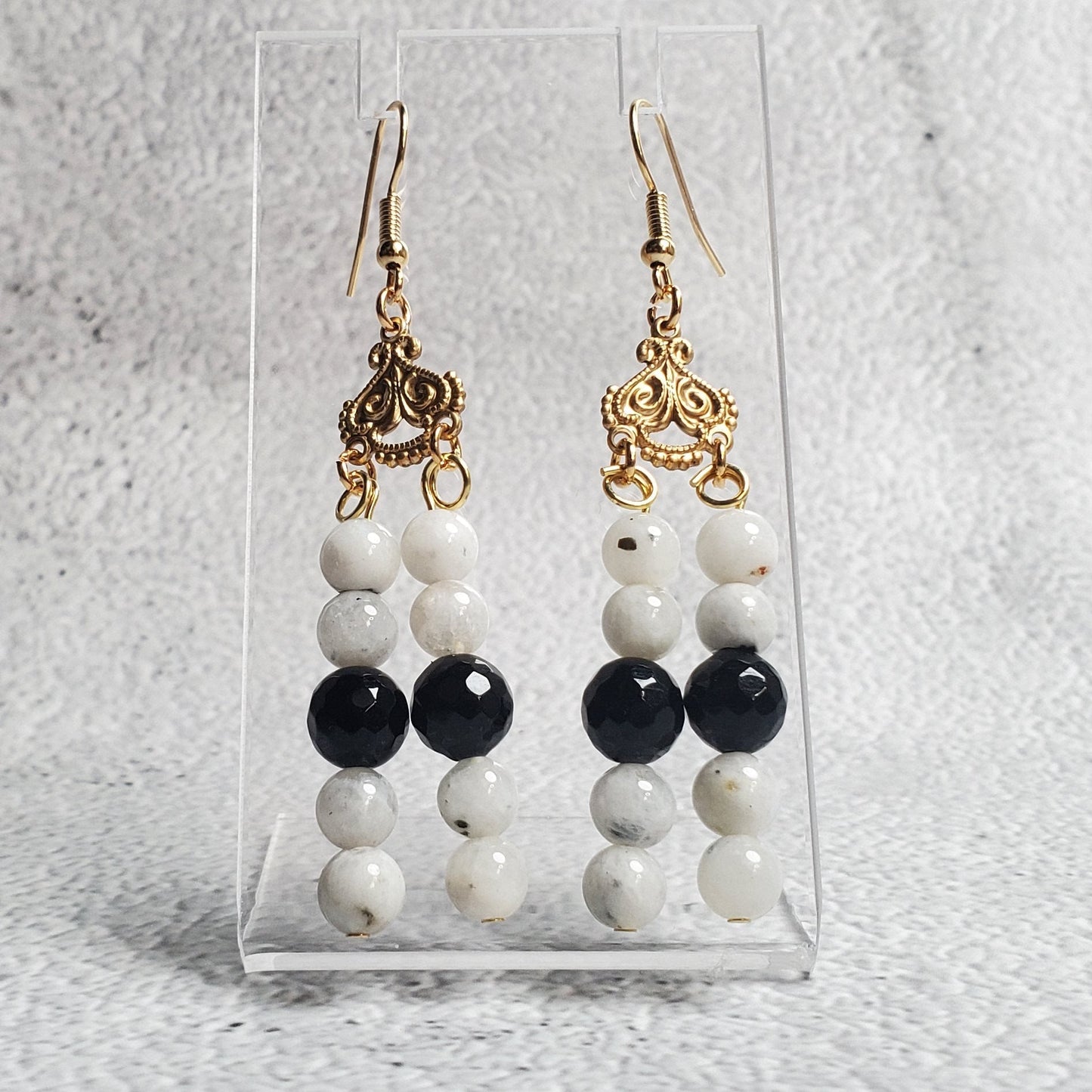 Elegant gemstone earrings featuring white moonstone and black onyx in a chandelier design