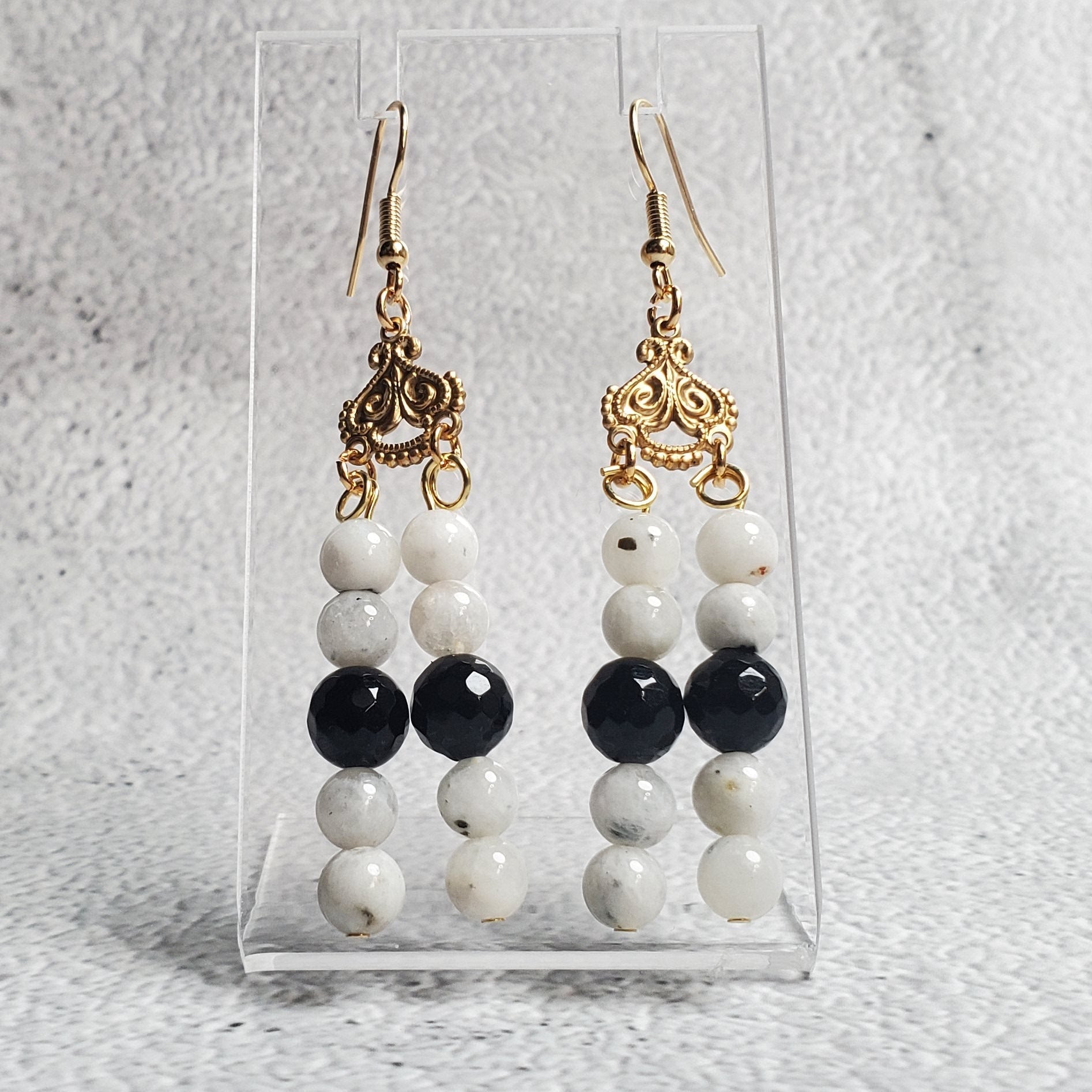 Elegant gemstone earrings featuring white moonstone and black onyx in a chandelier design