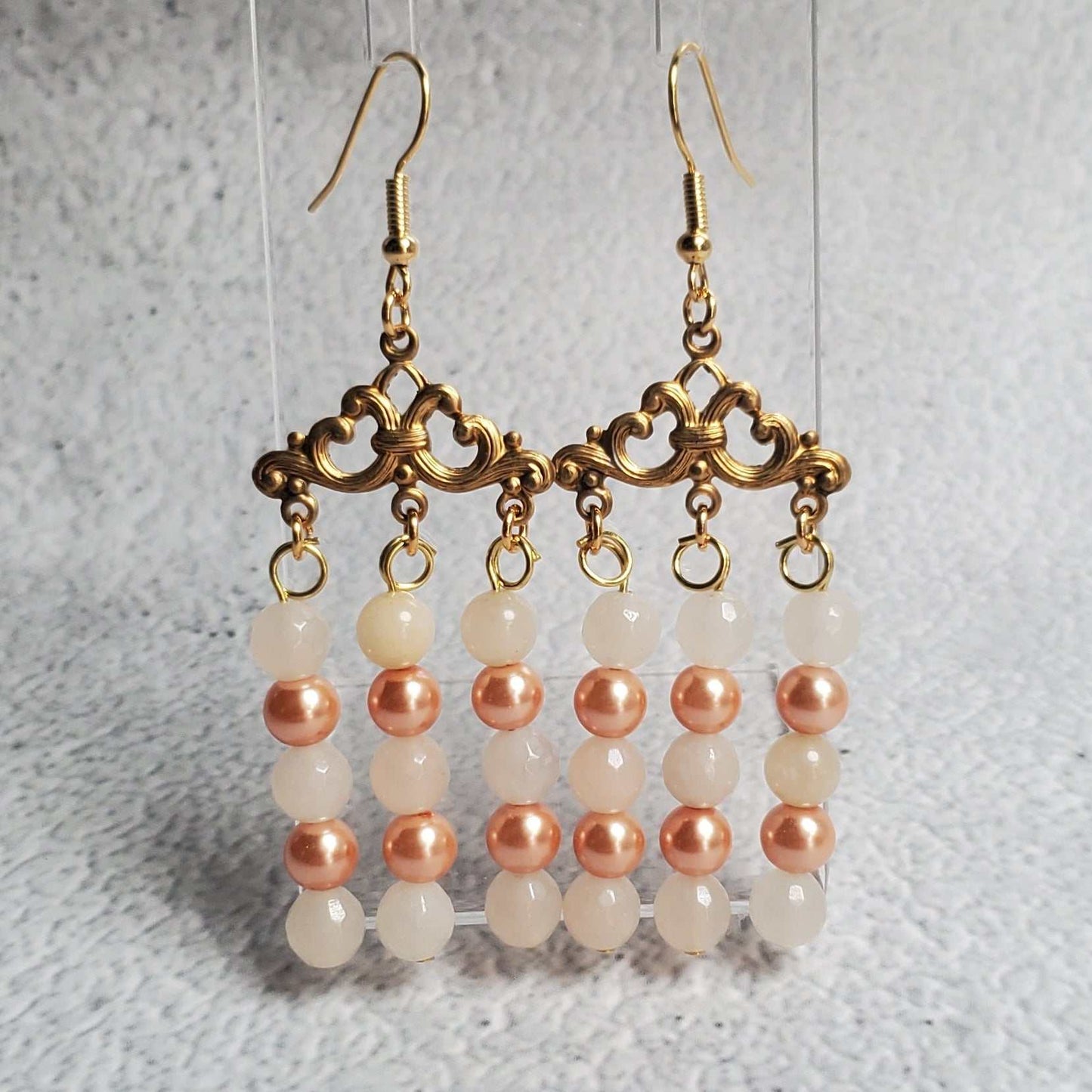 Handcrafted gemstone earrings featuring white moonstone and peach pearls in a chandelier design