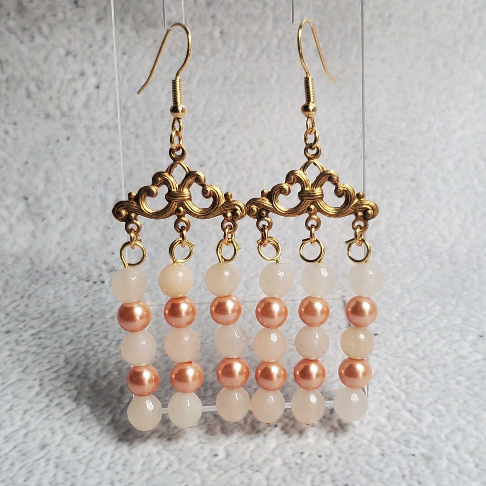 Handcrafted gemstone earrings featuring white moonstone and peach pearls in a chandelier design