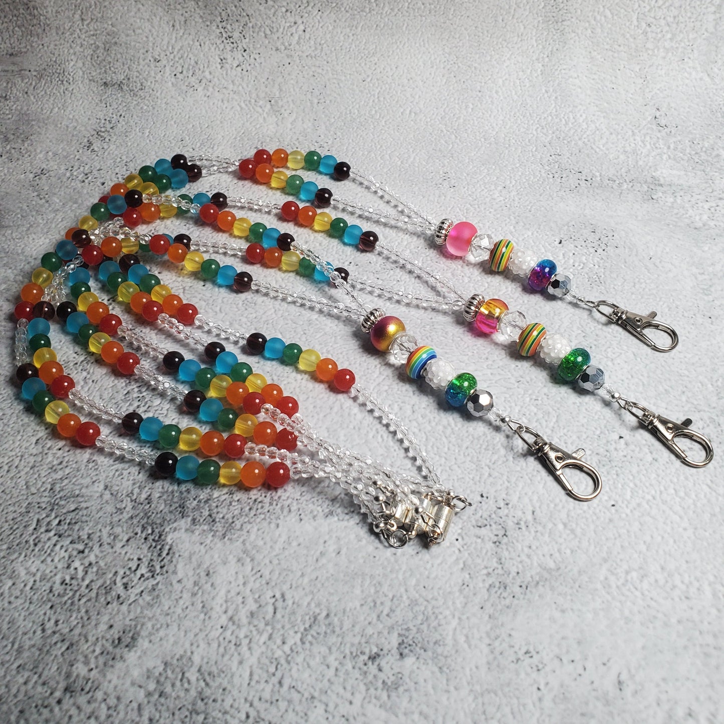 Handcrafted rainbow lanyard with colorful glass beads and European charm beads, featuring a magnetic clasp and lobster claw clasp for keys or ID badges.