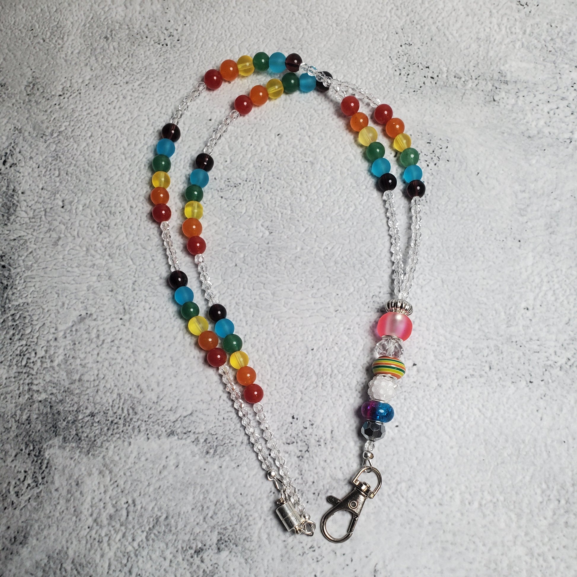 Handcrafted rainbow lanyard with colorful glass beads and European charm beads, featuring a secure lobster claw clasp and magnetic closure for keys or ID badges.