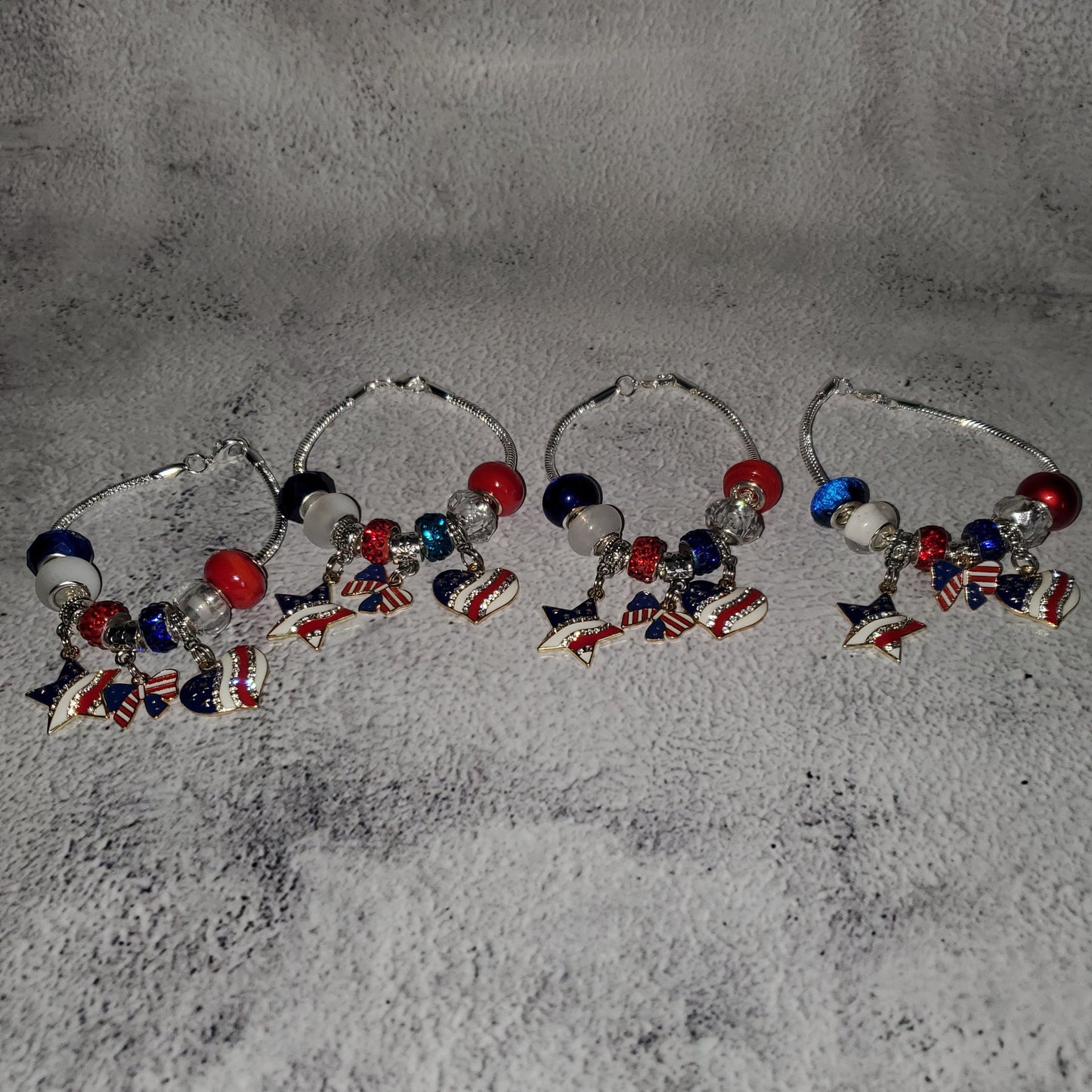 Silver snake chain charm bracelet with red, white, and blue beads and rhinestone American flag charms for 4th of July celebration