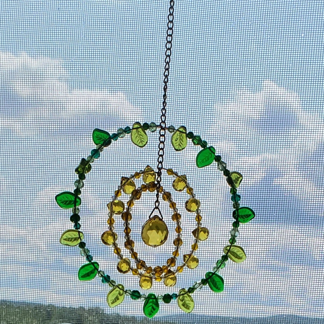 Handcrafted sunflower mandala crystal suncatcher with yellow, amber, and green beads and topaz prism