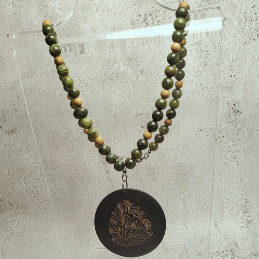 Handcrafted gemstone necklace featuring genuine Chinese jade beads and a wood pendant with floral etching