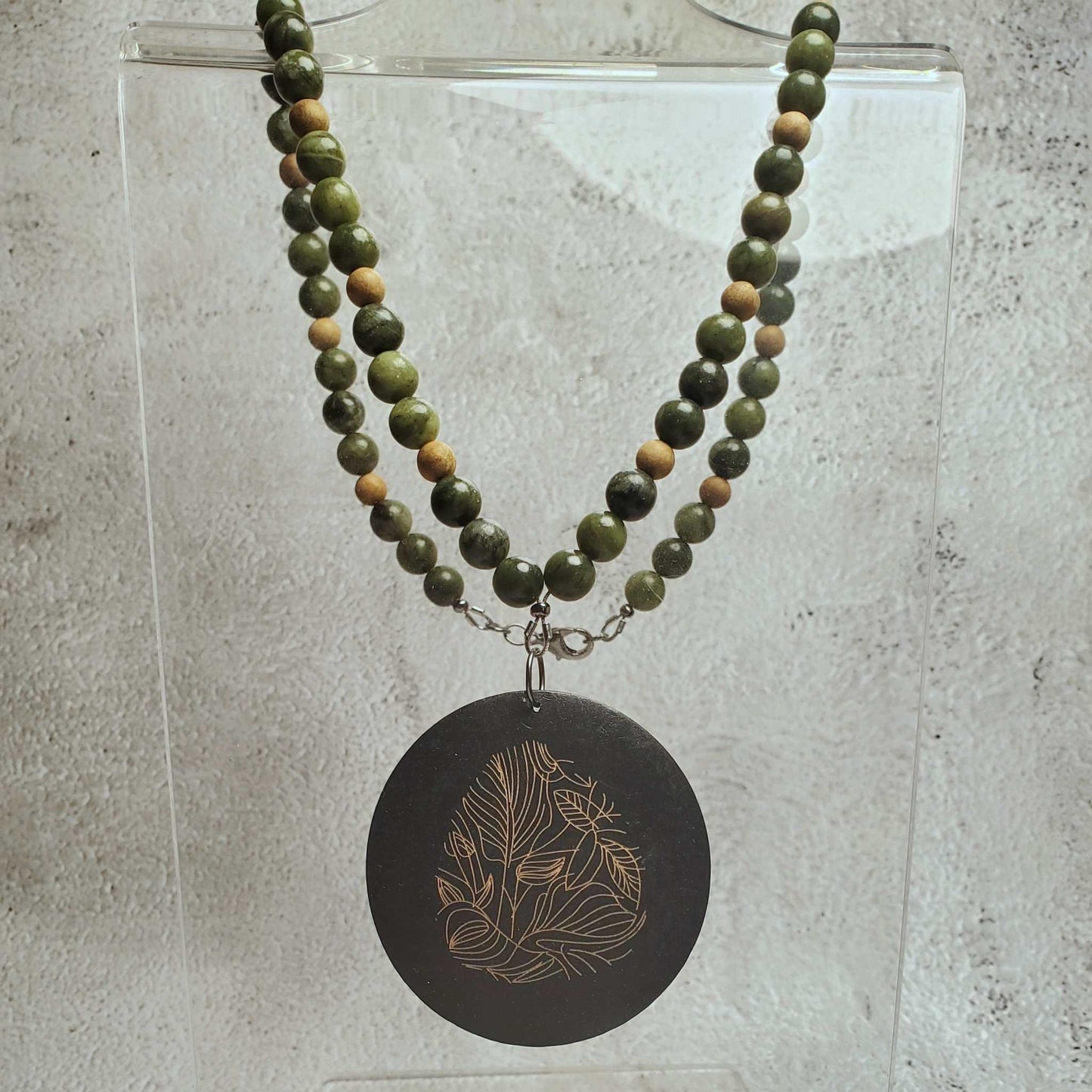 Handcrafted gemstone necklace with Chinese jade beads and wood pendant featuring floral design