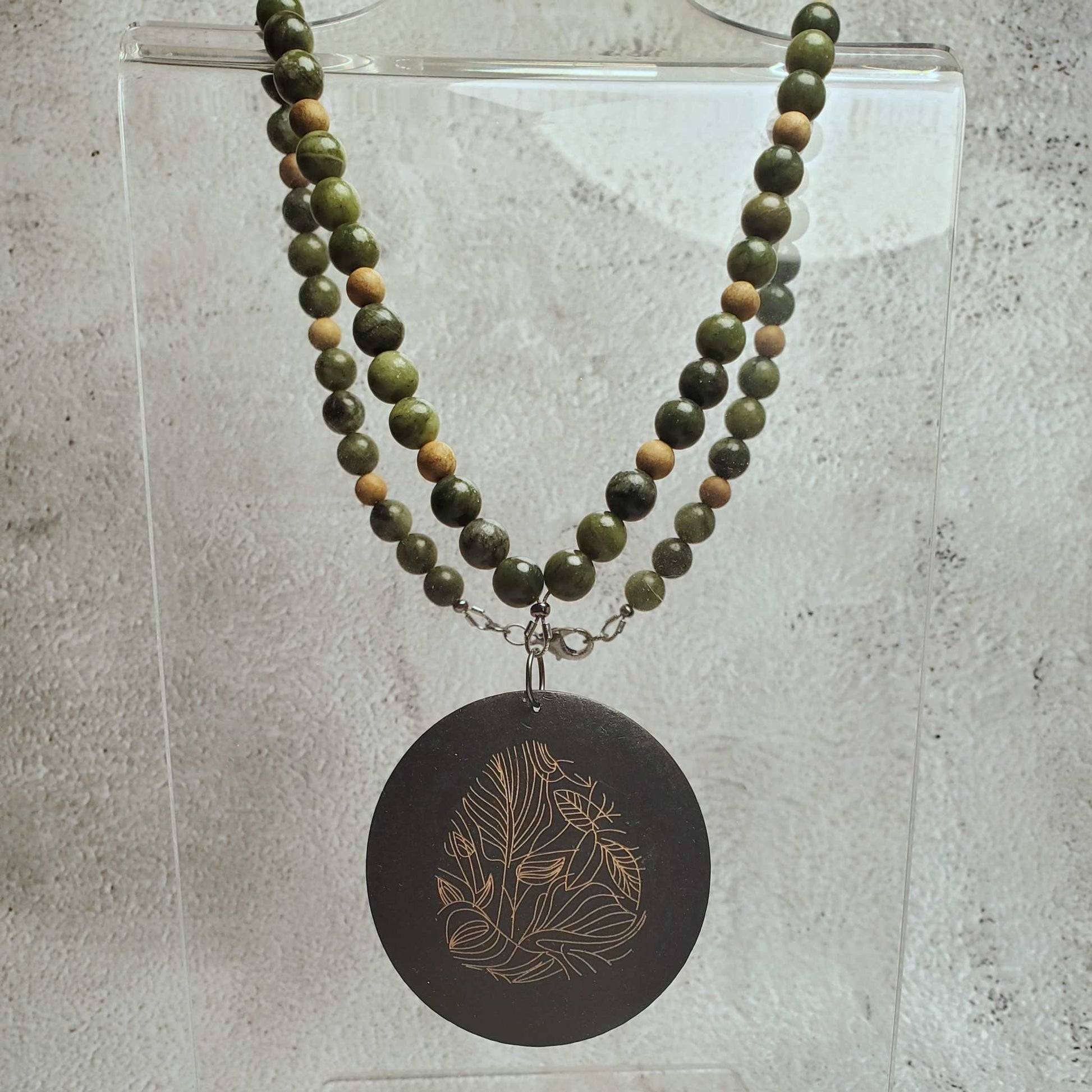 Handcrafted gemstone necklace with Chinese jade beads and wood pendant featuring floral design
