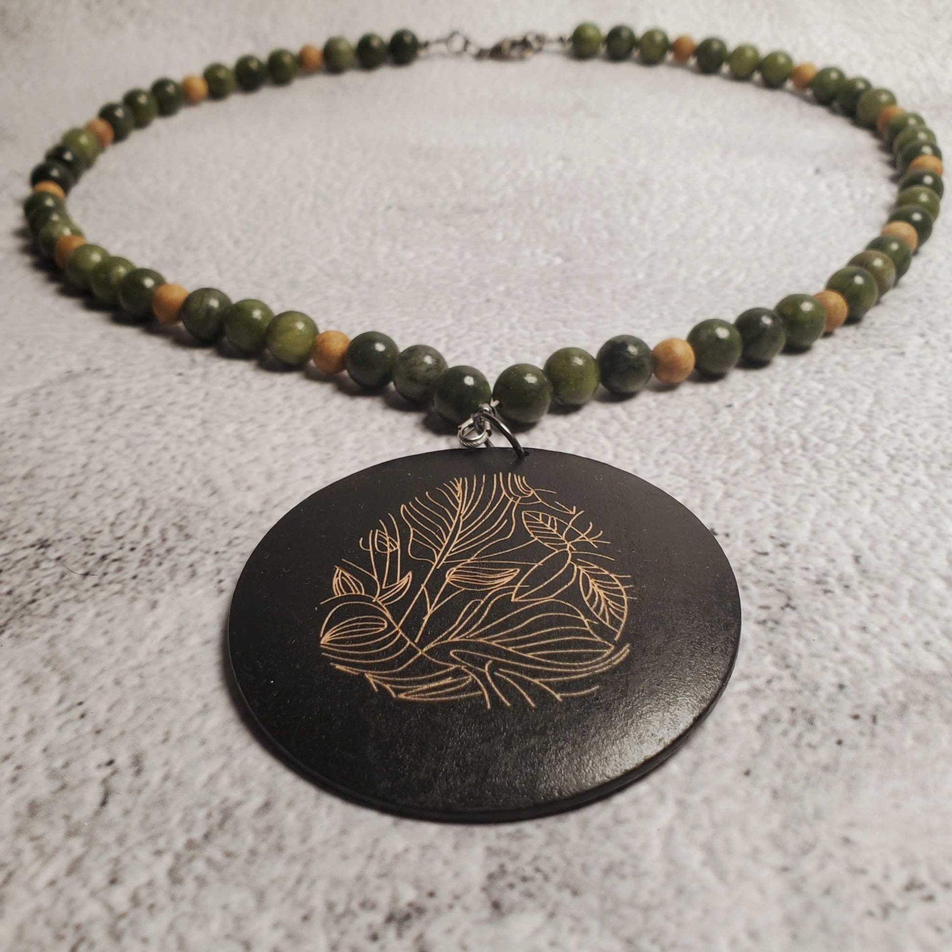 Handcrafted gemstone necklace featuring genuine Chinese jade and wood pendant with floral design