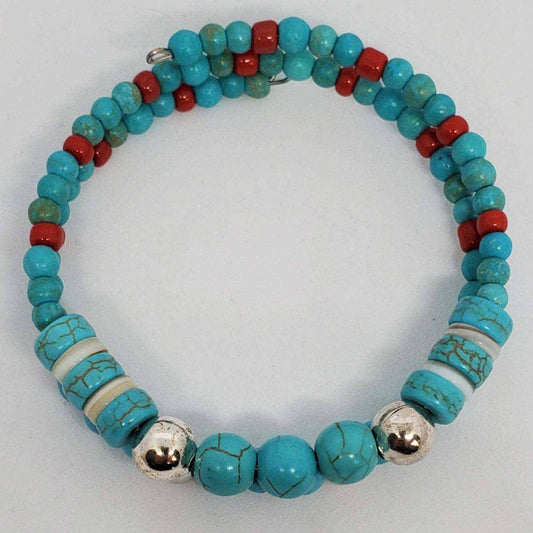 Turquoise and silver gemstone bracelet with red accents in southwestern style cuff design