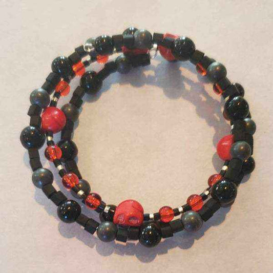 Red skull bracelet with howlite skull beads, black and red glass beads, and Czech glass accents on flexible memory wire.