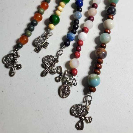 Handcrafted prayer bracelets with semiprecious stone beads, wooden accents, and pewter religious charms.