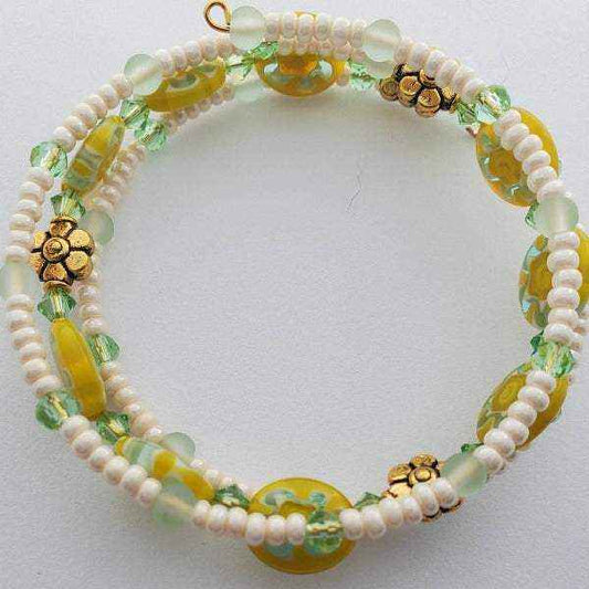Yellow and aqua Millefiori floral cuff bracelet with white beads and gold flower accents on memory wire design