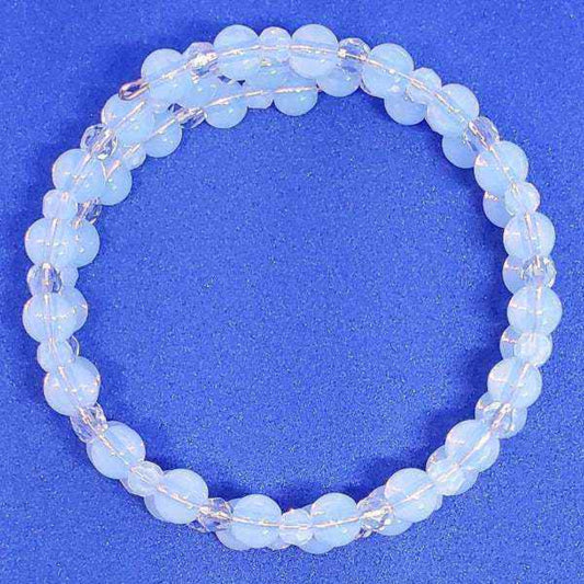 Opalite and crystal cuff gemstone bracelet with adjustable memory wire on blue background