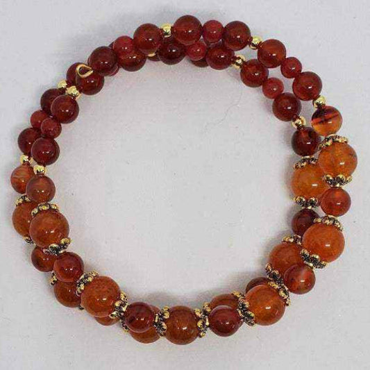 Carnelian gemstone bracelet with orange-red beads and gold-tone spacers on flexible memory wire cuff