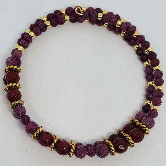 Ruby gemstone bracelet with gold-toned spacers in a flexible cuff design