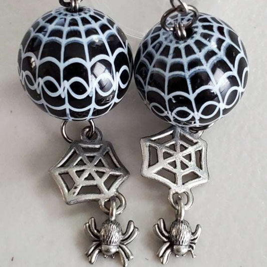 Black spiderweb drop earrings with acrylic bead and pewter spider charm.